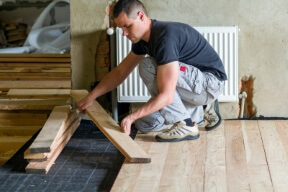 man installing a hardwood floor